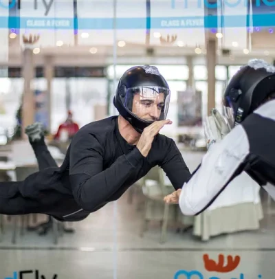 Instructor de vuelo dando indicaciones a una persona en el túnel de viento